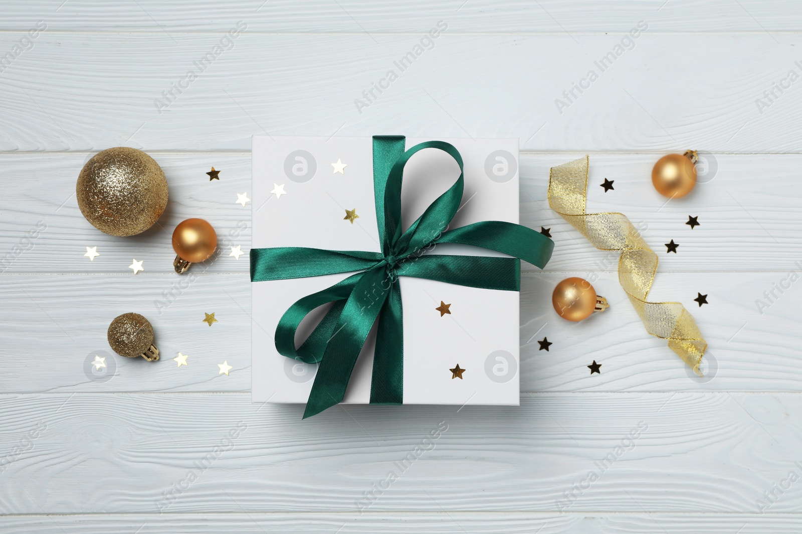 Photo of Flat lay composition with beautiful gift boxes and different Christmas decor on white wooden table