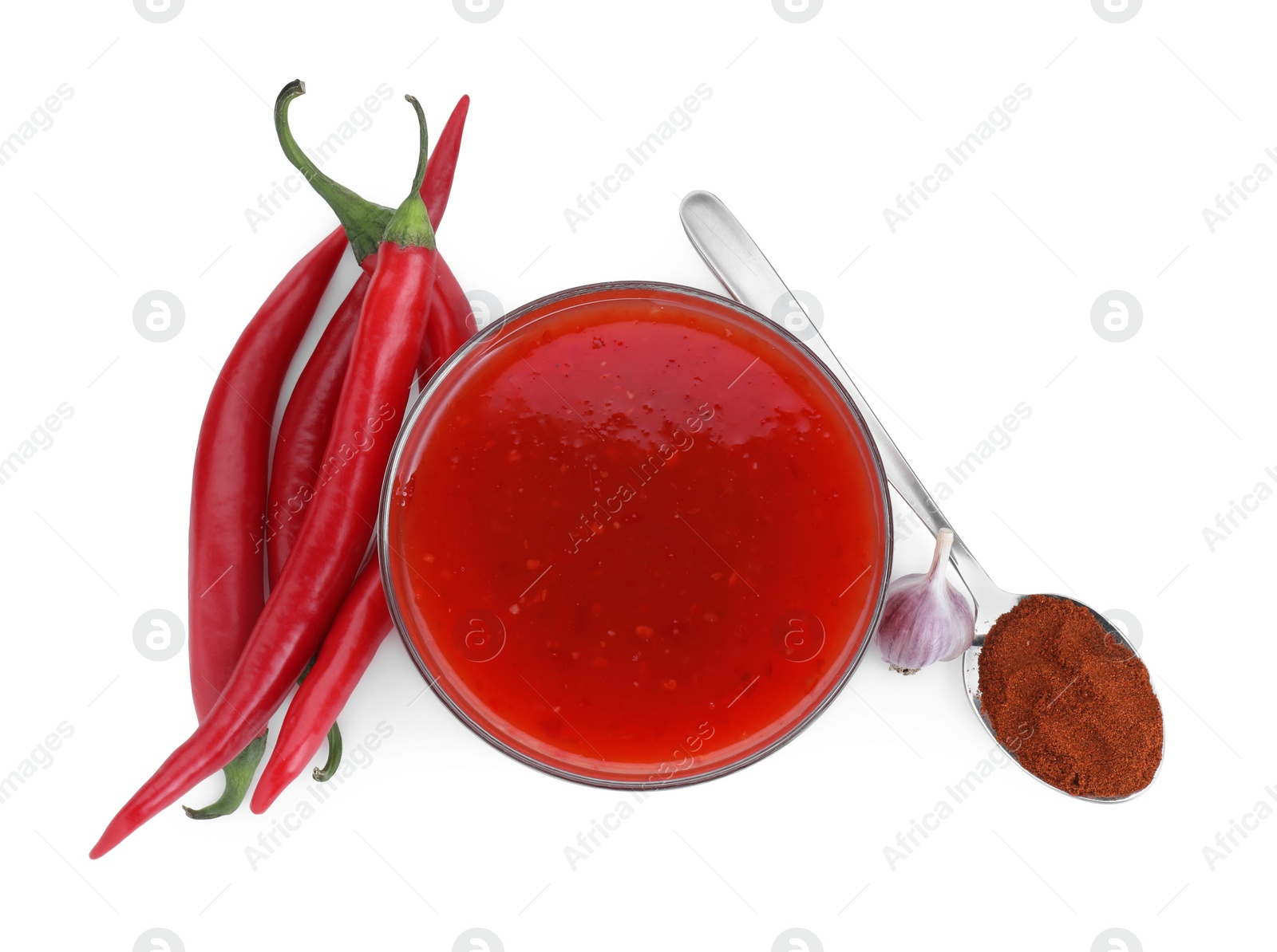 Photo of Spicy chili sauce in bowl and ingredients isolated on white, top view