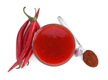 Photo of Spicy chili sauce in bowl and ingredients isolated on white, top view