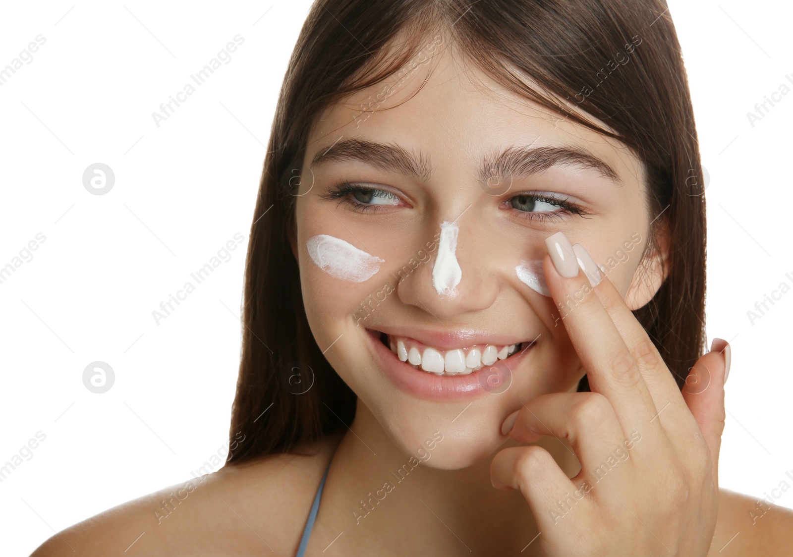 Photo of Teenage girl applying sun protection cream on her face against white background, closeup