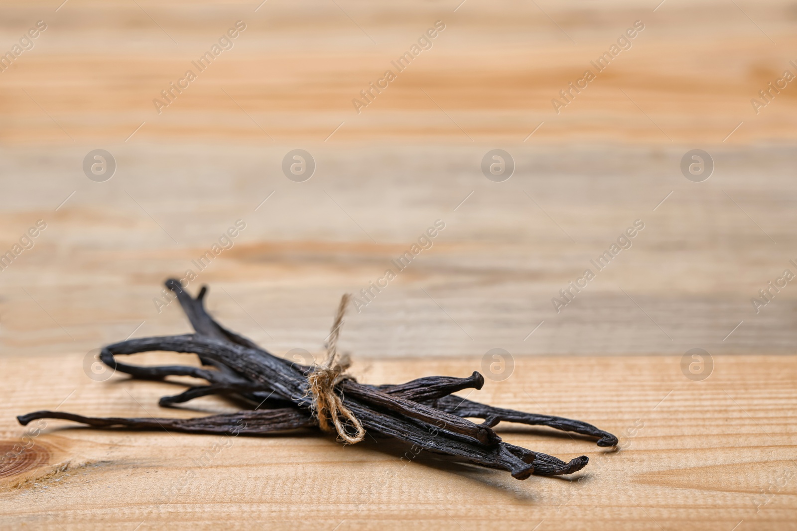 Photo of Aromatic vanilla sticks on wooden background