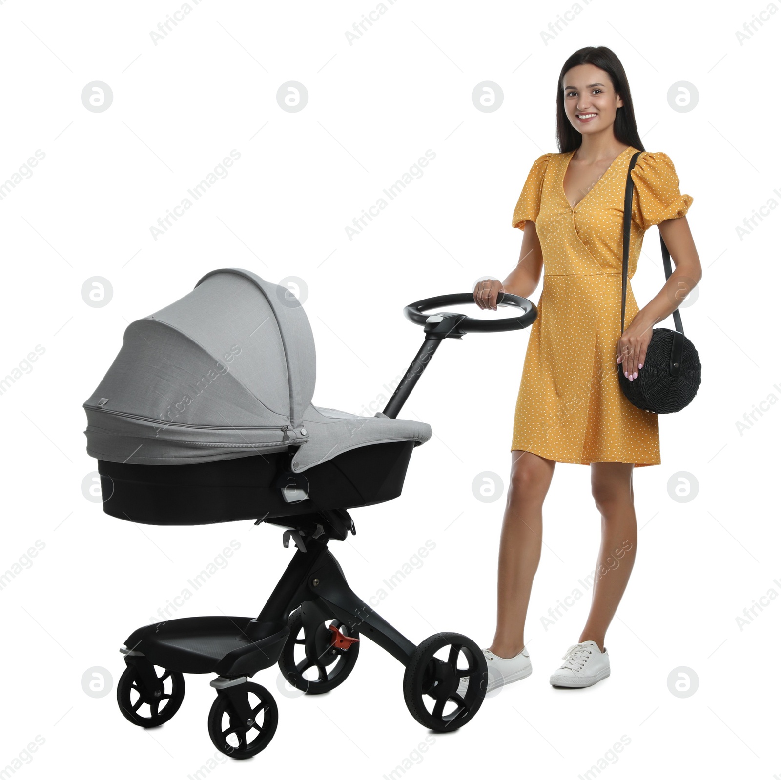 Photo of Happy young woman with baby stroller on white background