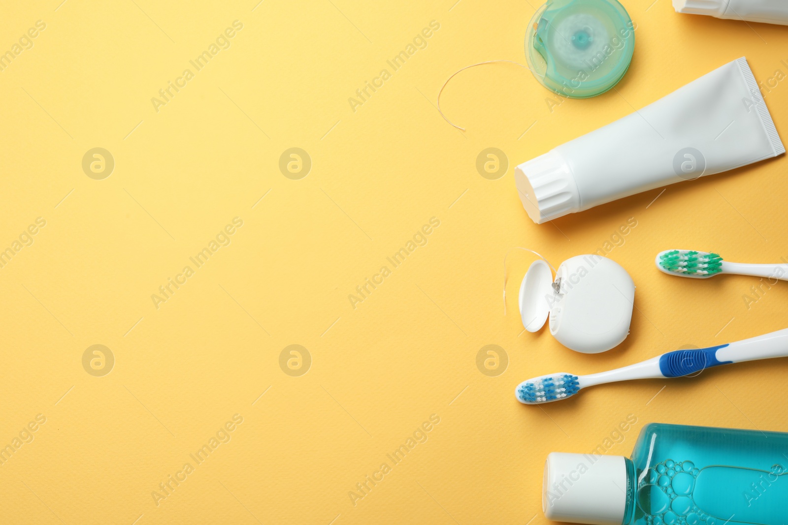 Photo of Flat lay composition with toothpaste, oral hygiene products and space for text on color background