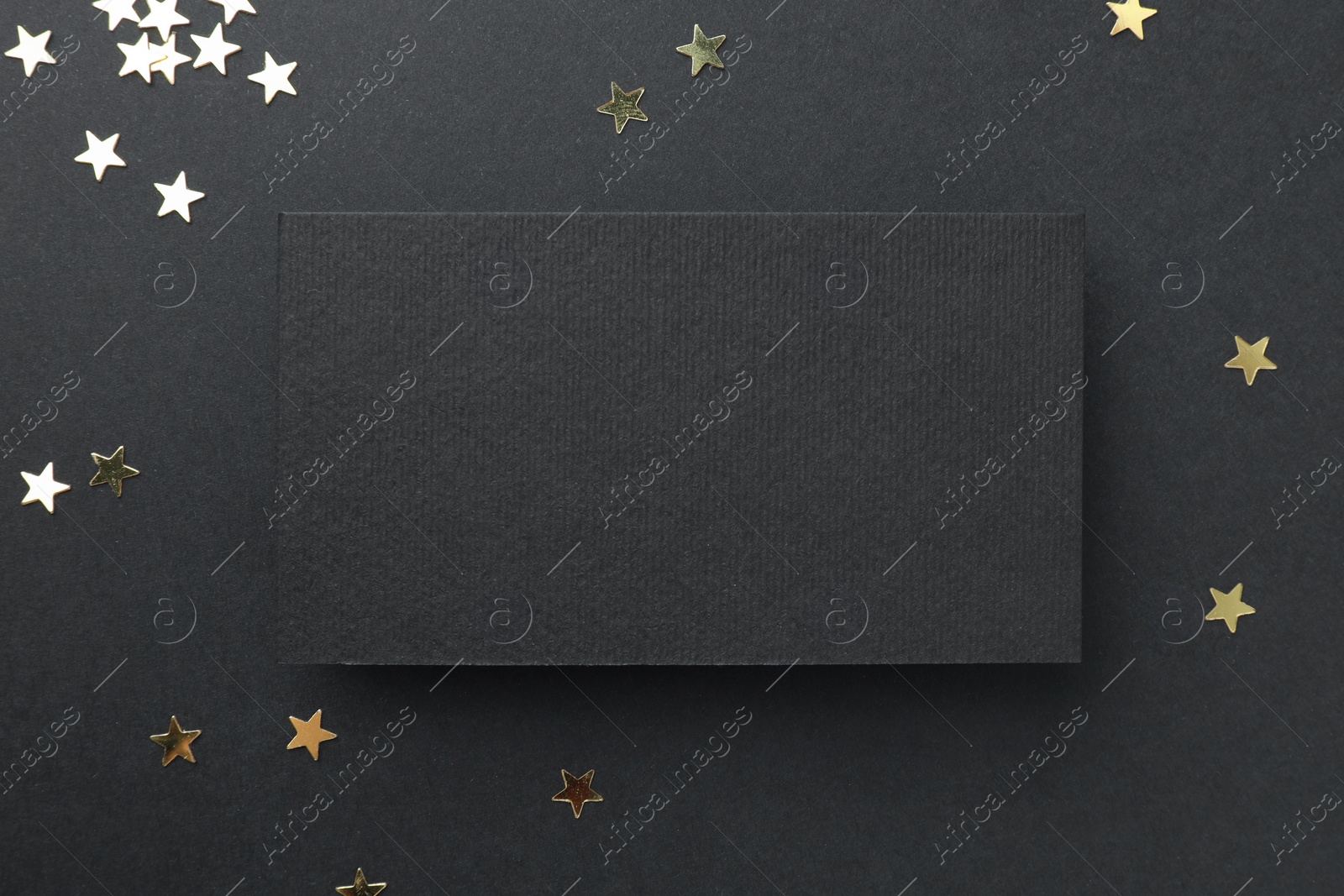 Photo of Blank business card and confetti on black background, top view. Mockup for design