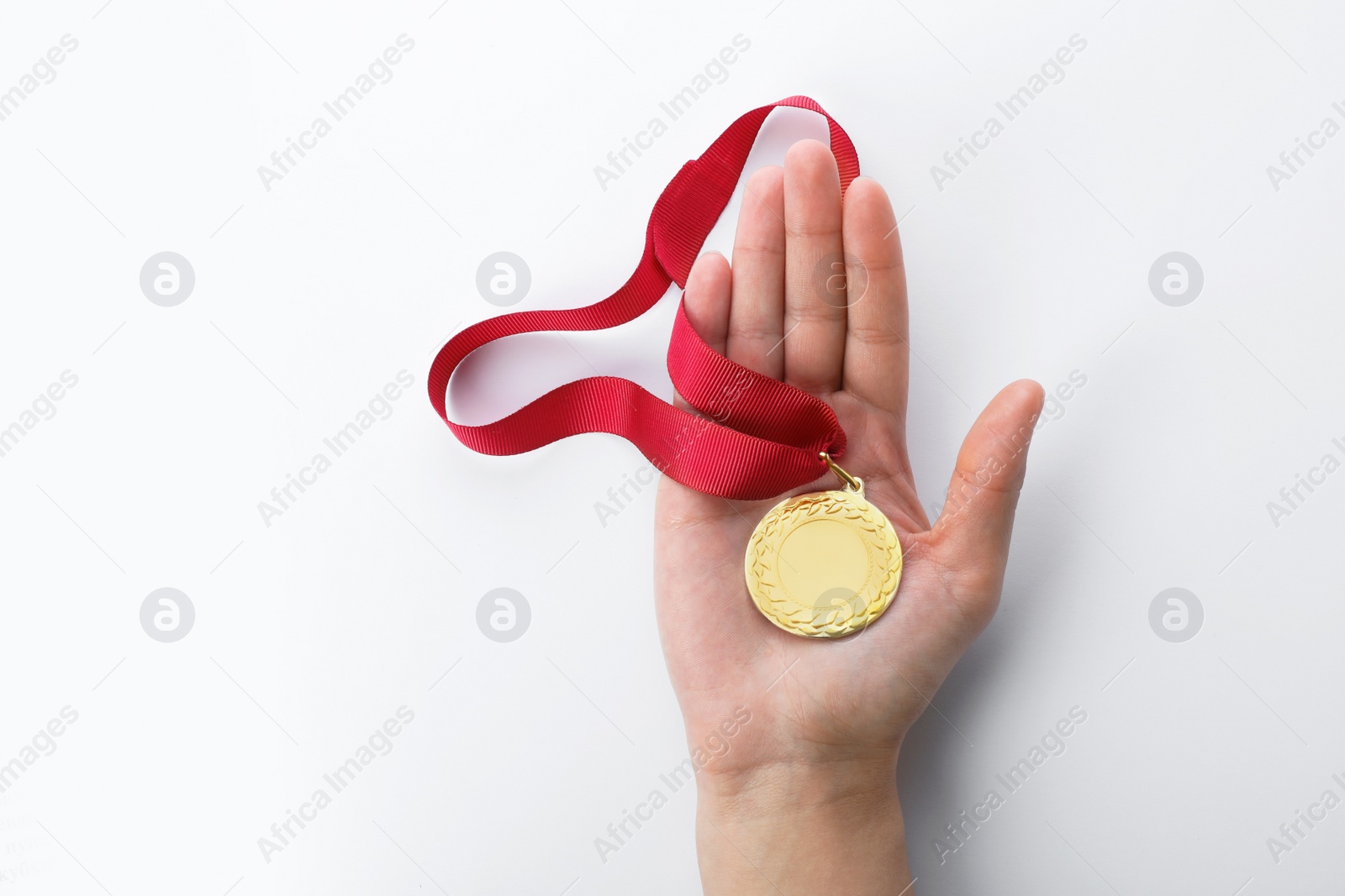 Photo of Woman holding gold medal with space for design on white background, top view. Victory concept