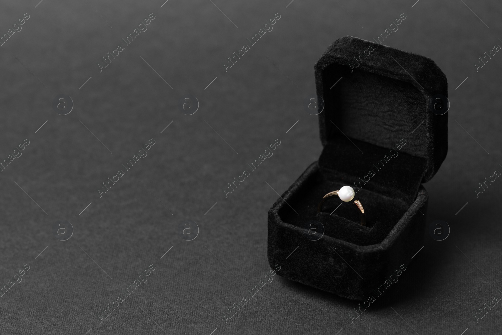 Photo of Jewelry box with ring on dark gray background, space for text