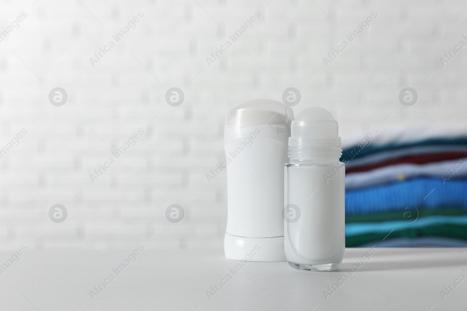 Photo of Different deodorants on white table. Space for text