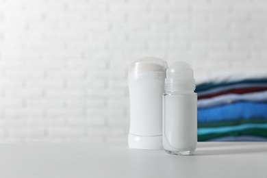 Different deodorants on white table. Space for text