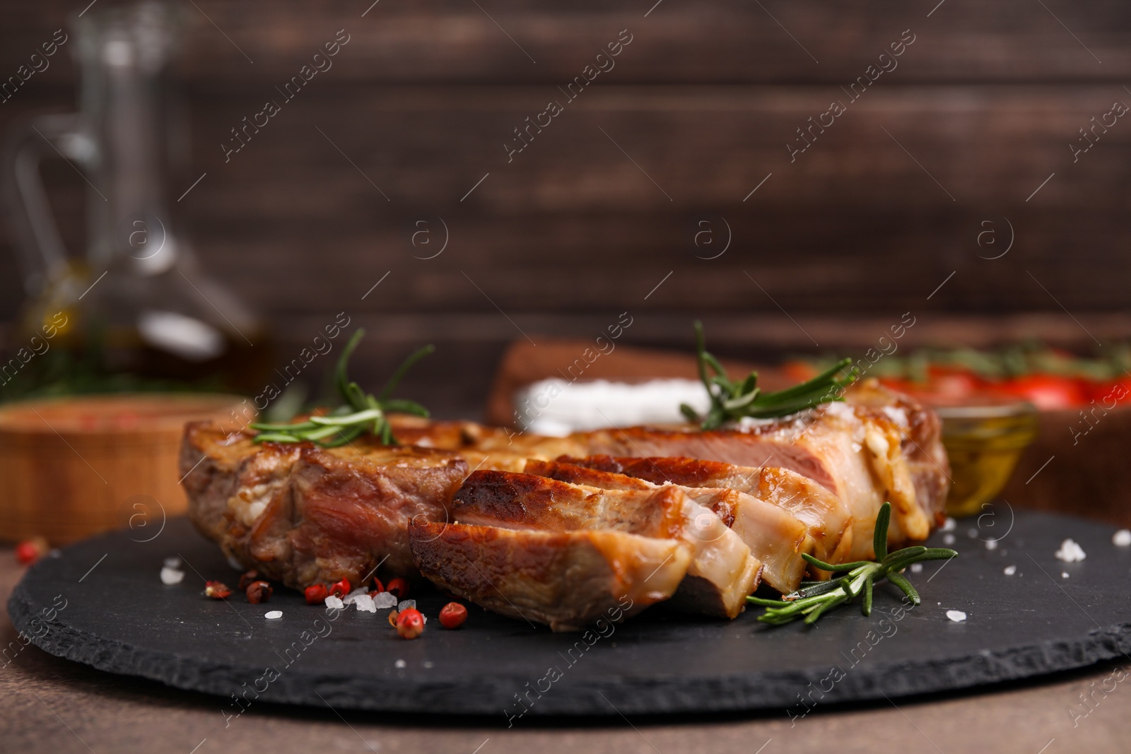 Photo of Pieces of delicious fried meat with rosemary and spices on table, closeup