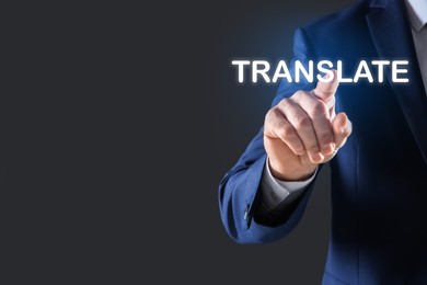 Image of Man pointing at virtual model of word TRANSLATE against grey background, closeup. Space for text