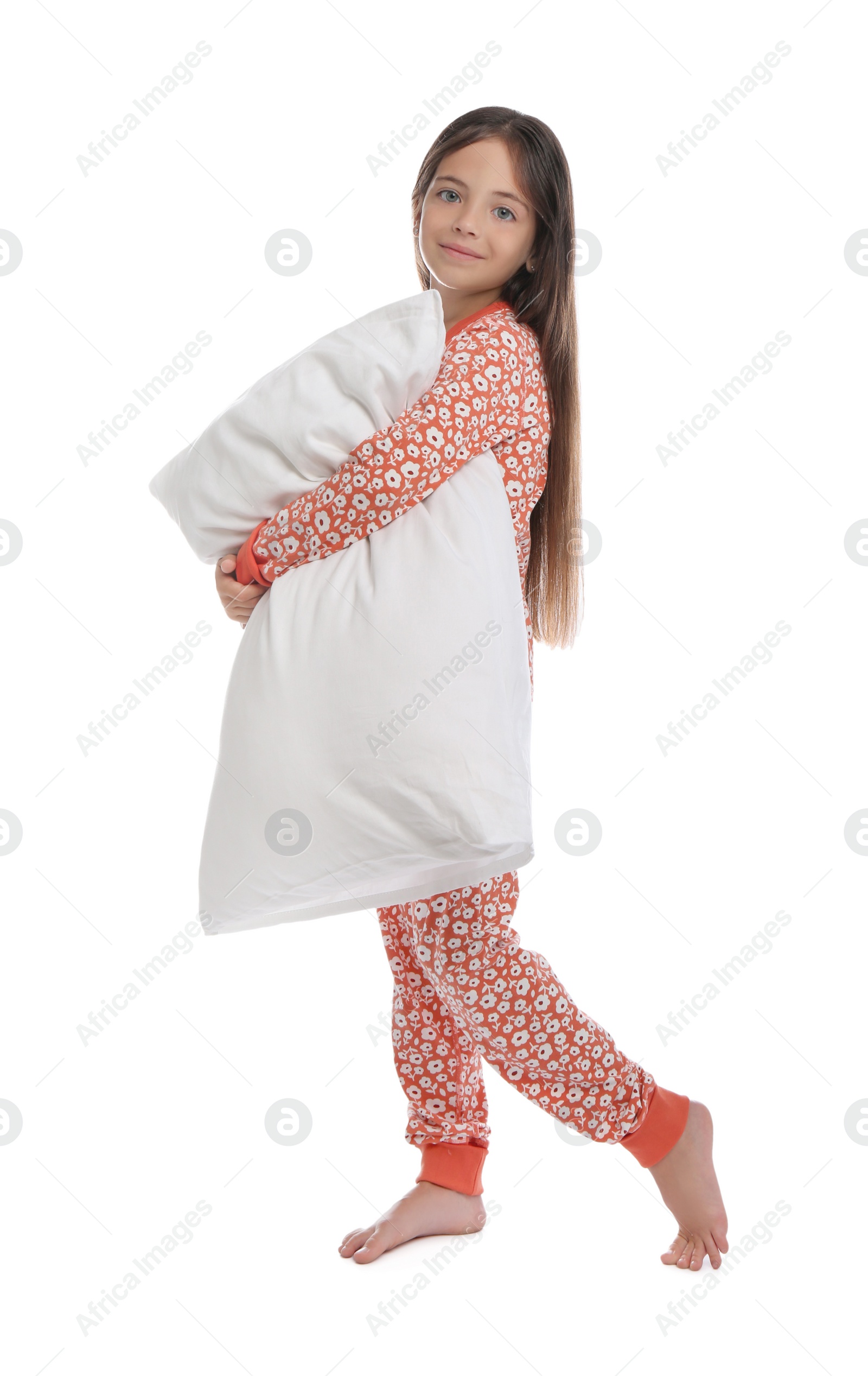 Photo of Cute girl wearing pajamas with pillow on white background