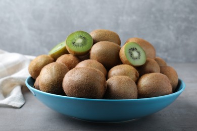 Photo of Fresh ripe kiwis in bowl on light grey table