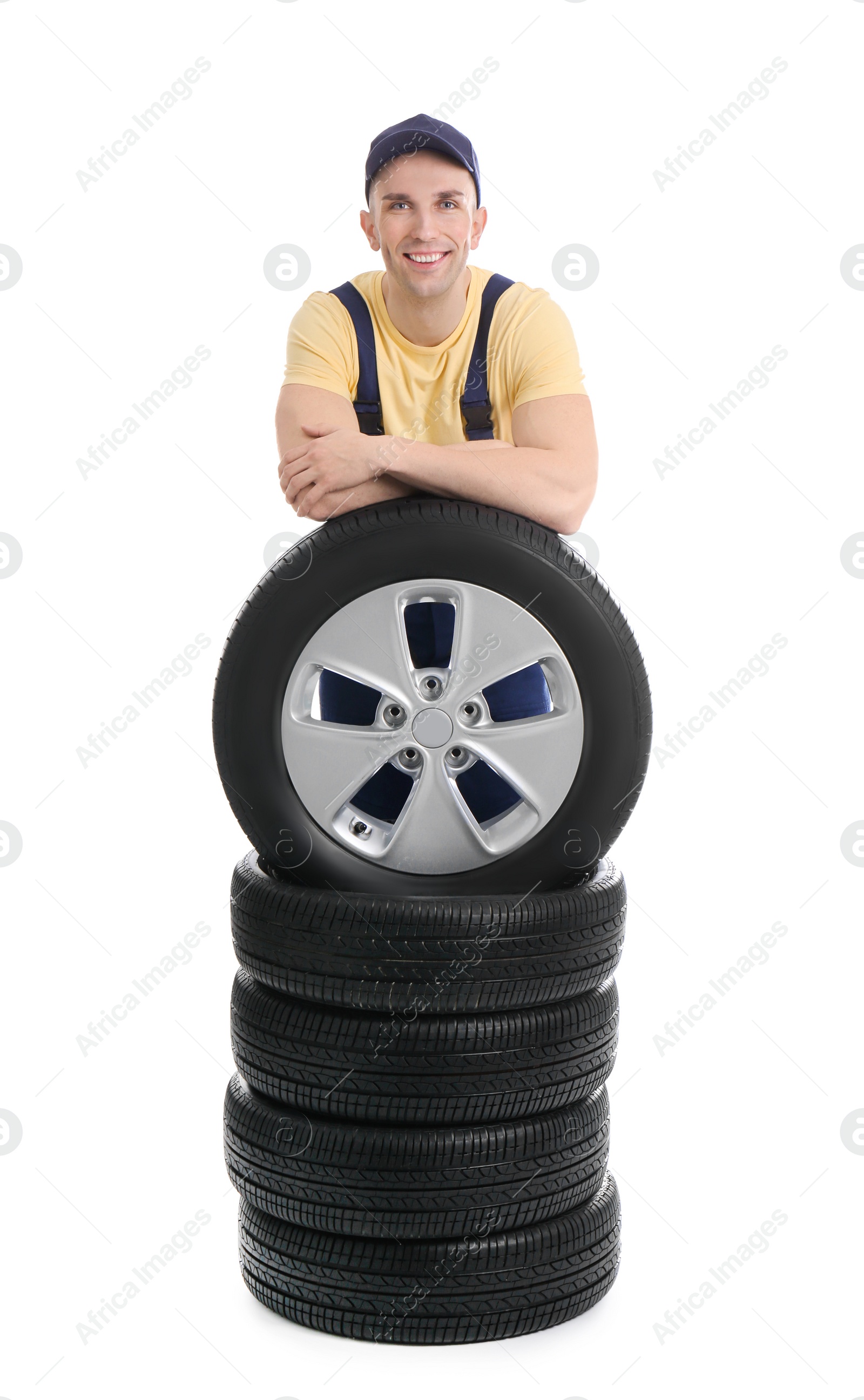 Photo of Male mechanic with car tires on white background