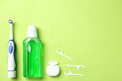 Photo of Flat lay composition with electric toothbrush and oral hygiene products on color background