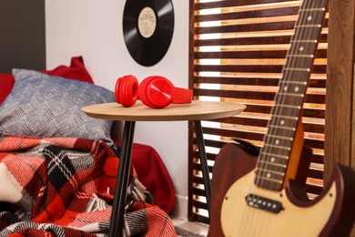 Photo of Red headphones on wooden table in teenager's room