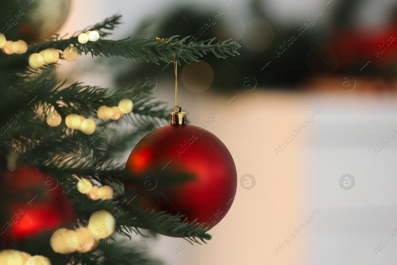 Photo of Christmas tree decorated with festive balls on light background, closeup. Space for text