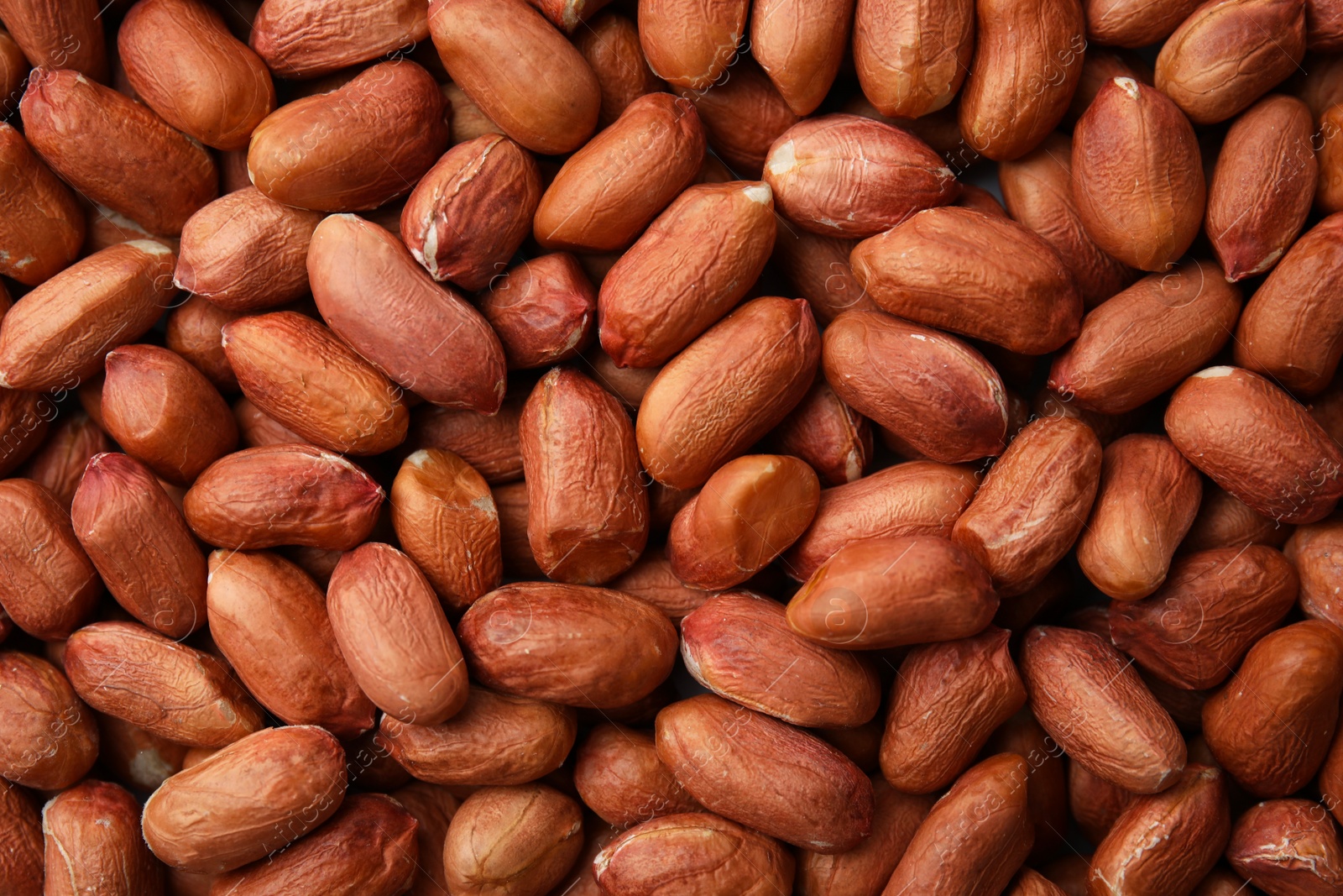 Photo of Many fresh unpeeled peanuts as background, top view