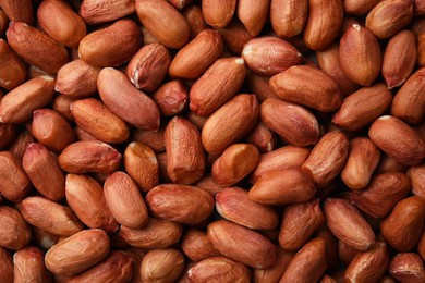 Photo of Many fresh unpeeled peanuts as background, top view