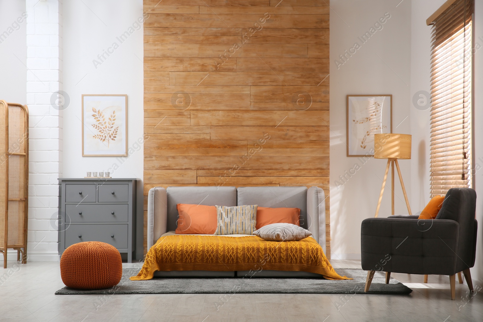 Photo of Room interior with sofa unfolded into bed near wooden wall