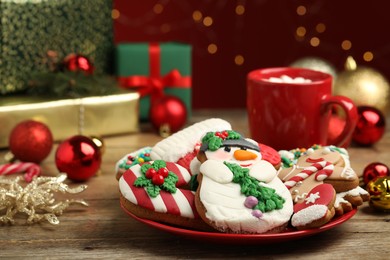 Photo of Delicious Christmas cookies on wooden table against blurred lights, closeup