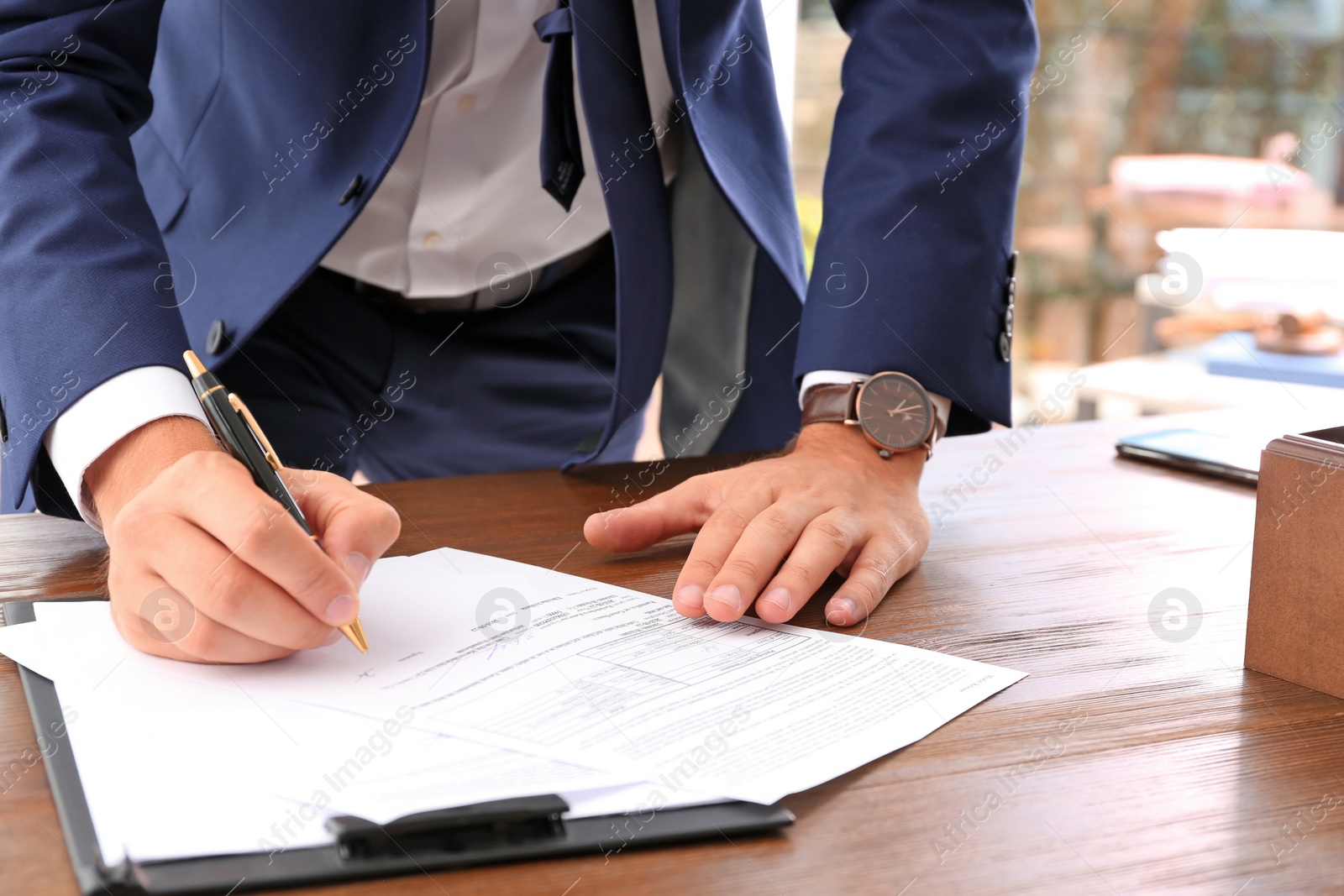 Photo of Lawyer working with documents at table, focus on hands