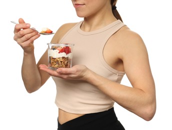 Photo of Woman eating tasty granola with fresh berries and yogurt on white background, closeup