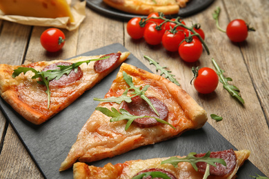 Photo of Tasty pepperoni pizza with arugula on wooden table