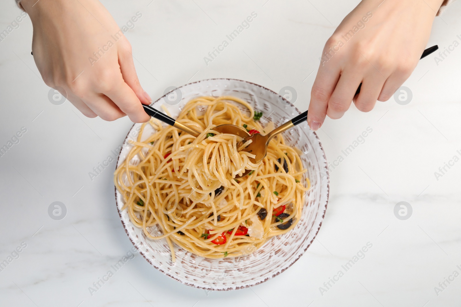 Photo of Woman eating delicious pasta at white marble table, top view