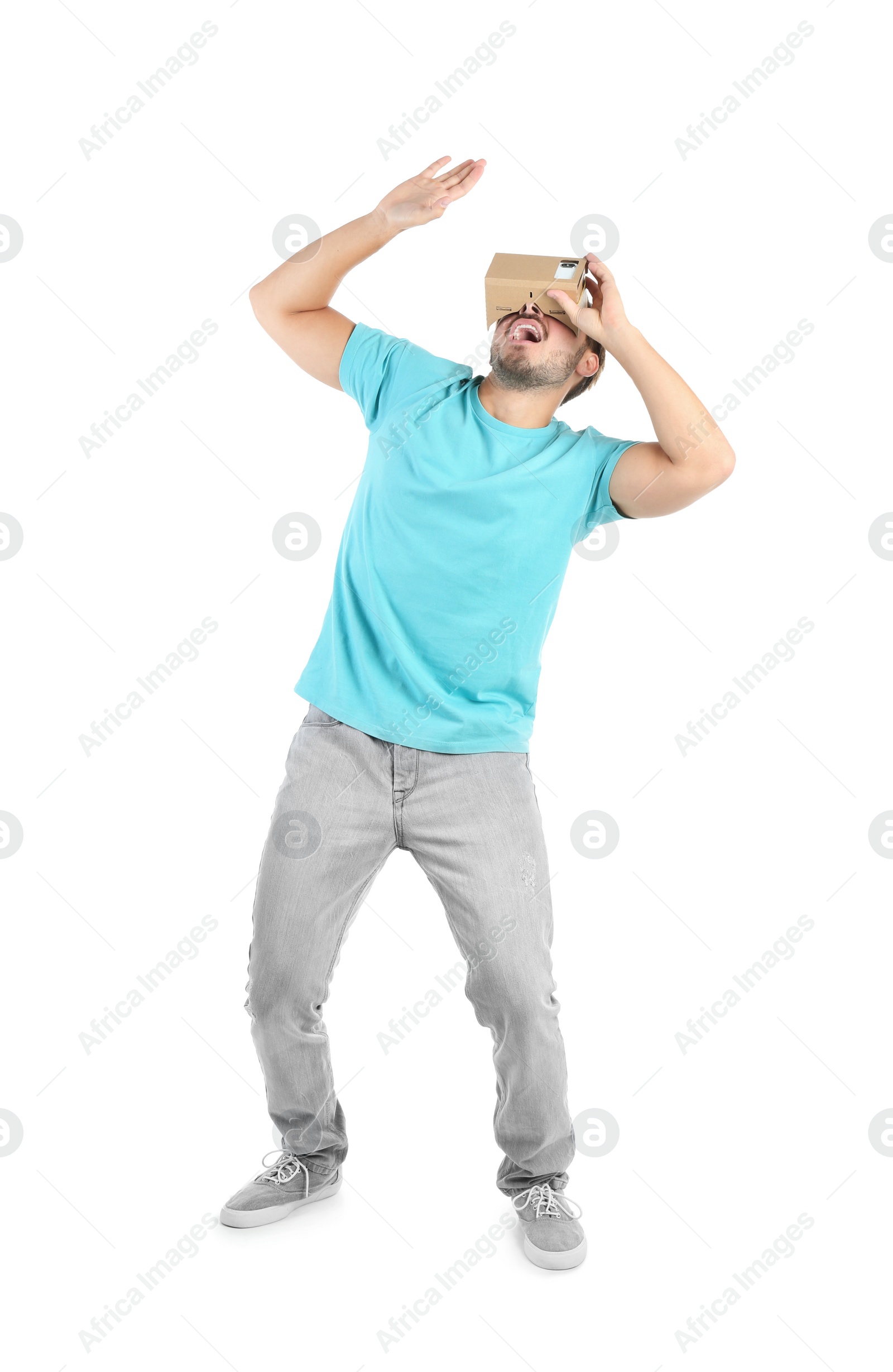 Photo of Young man using cardboard virtual reality headset, isolated on white