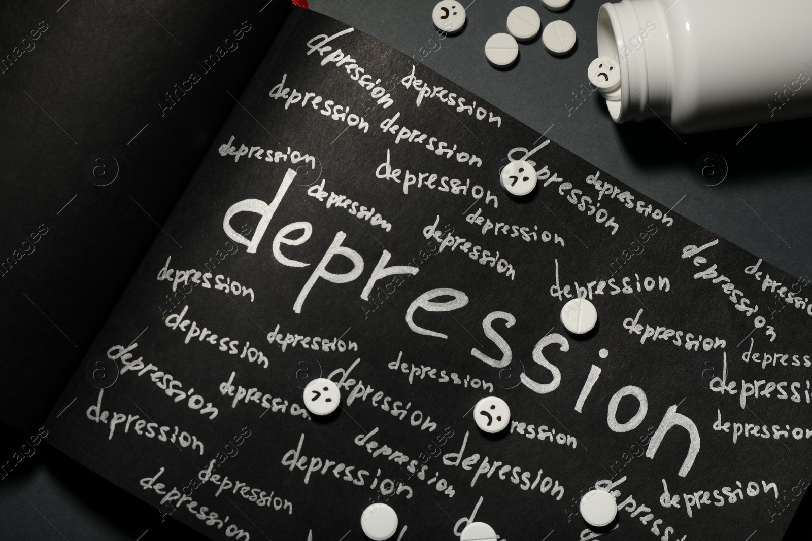 Photo of Sketchbook with words Depression and pills on black table, flat lay