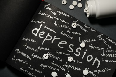 Photo of Sketchbook with words Depression and pills on black table, flat lay