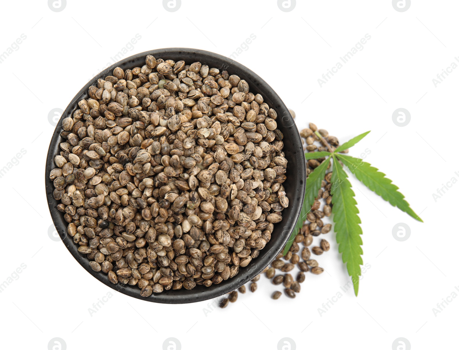 Photo of Bowl with hemp seeds and leaf on white background, top view