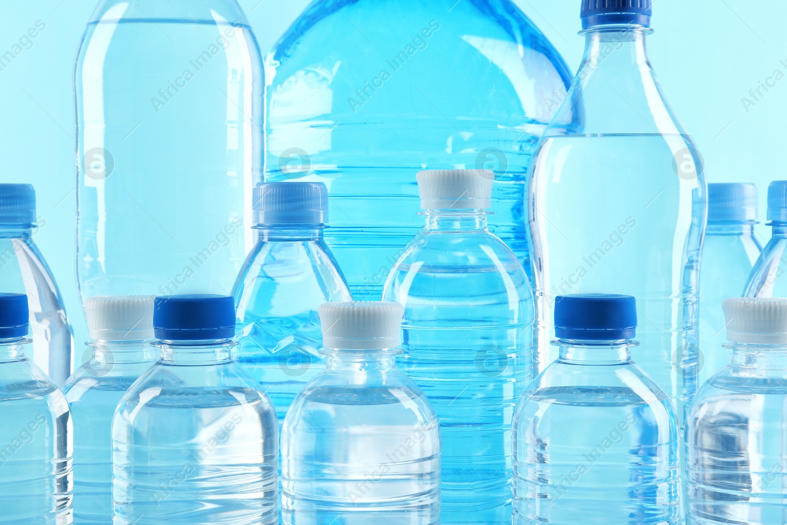 Photo of Set of different plastic bottles with pure water on color background