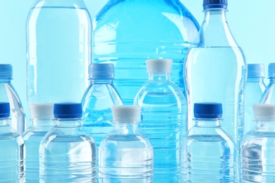 Set of different plastic bottles with pure water on color background