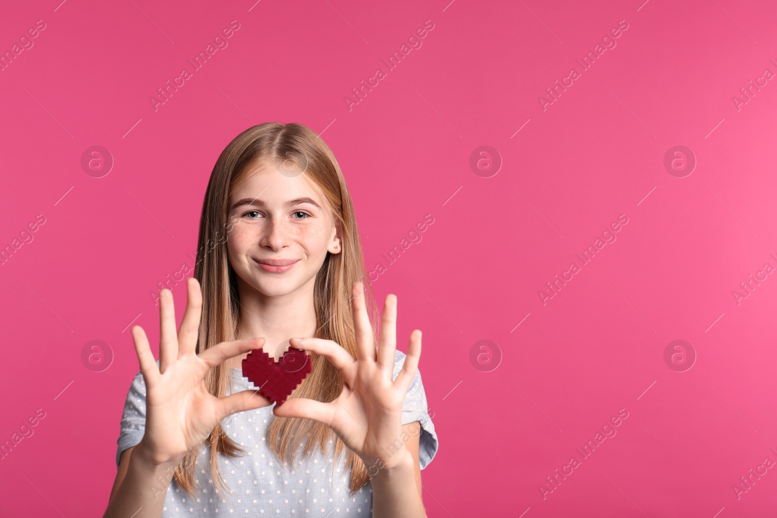 Photo of Pretty teenage girl with decorative heart on color background. Space for text