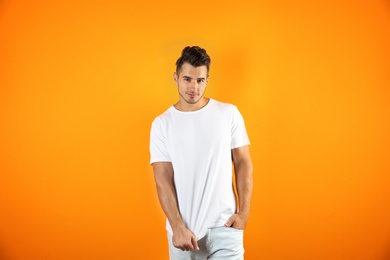 Young man in t-shirt on color background. Mockup for design