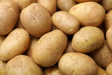 Photo of Fresh raw potatoes as background, top view