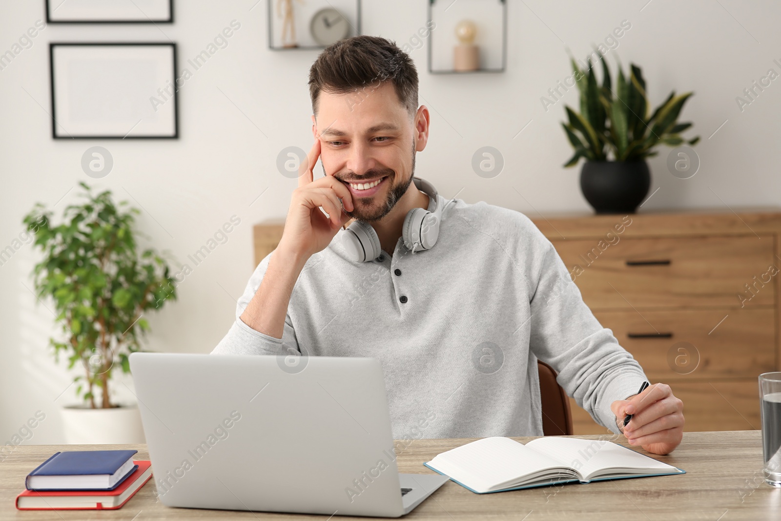 Photo of Man studying on laptop at home. Online translation course