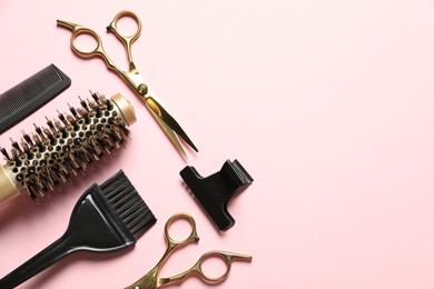 Photo of Professional hair dresser tools on pink background, flat lay. Space for text