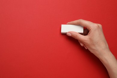 Photo of Woman erasing something on red background, closeup. Space for text