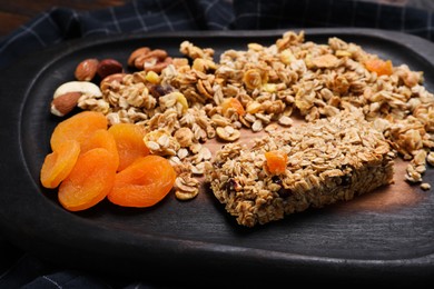 Tasty granola bar and ingredients on table