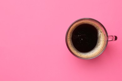Photo of Fresh coffee in cup on pink background, top view. Space for text