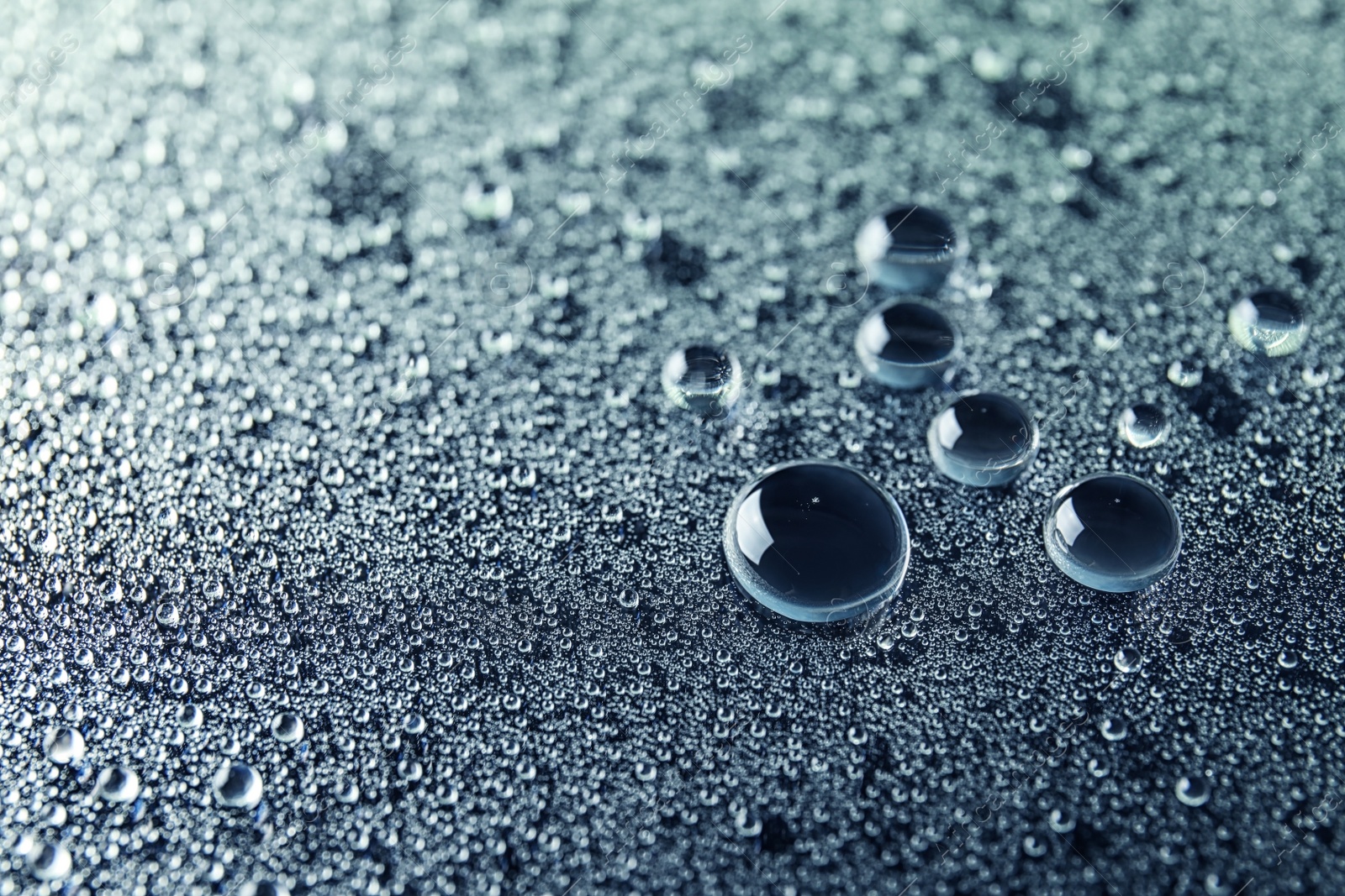 Photo of Many clean water drops on dark background