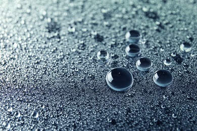 Many clean water drops on dark background