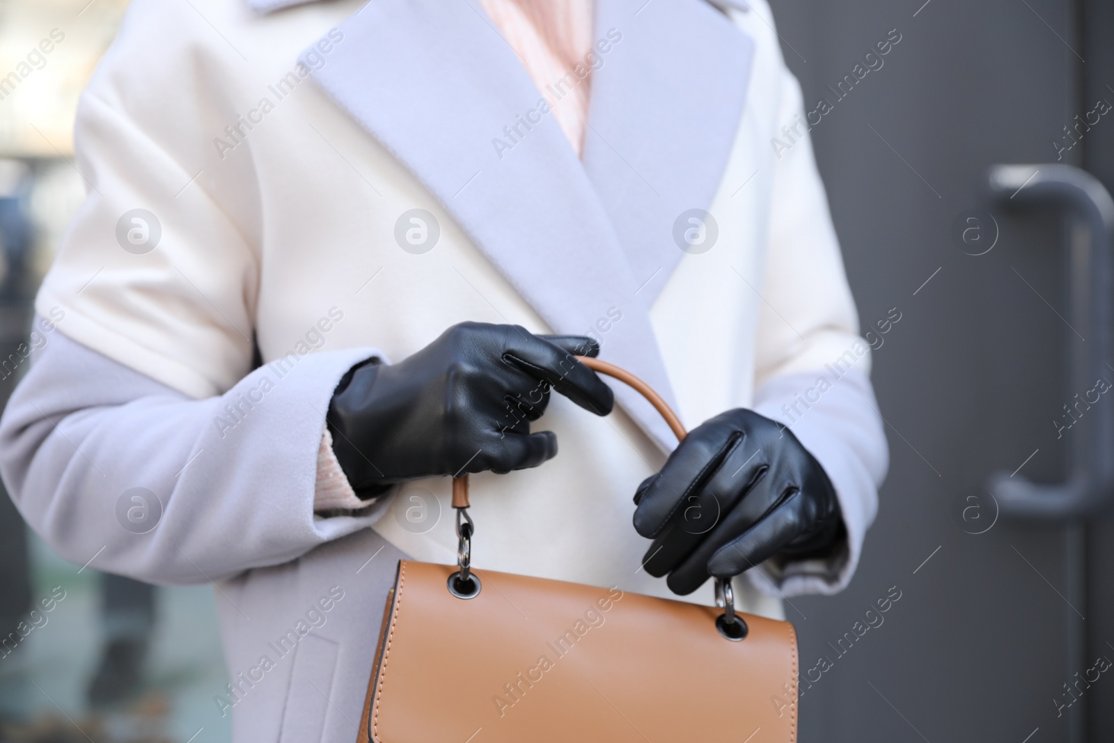 Photo of Woman with leather gloves and stylish bag outdoors, closeup