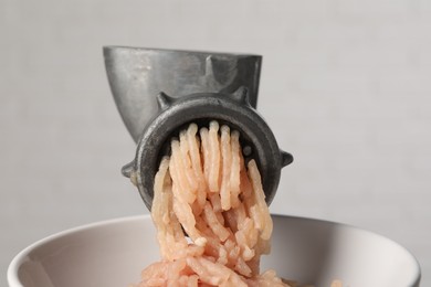 Photo of Metal meat grinder with chicken mince on light background, closeup