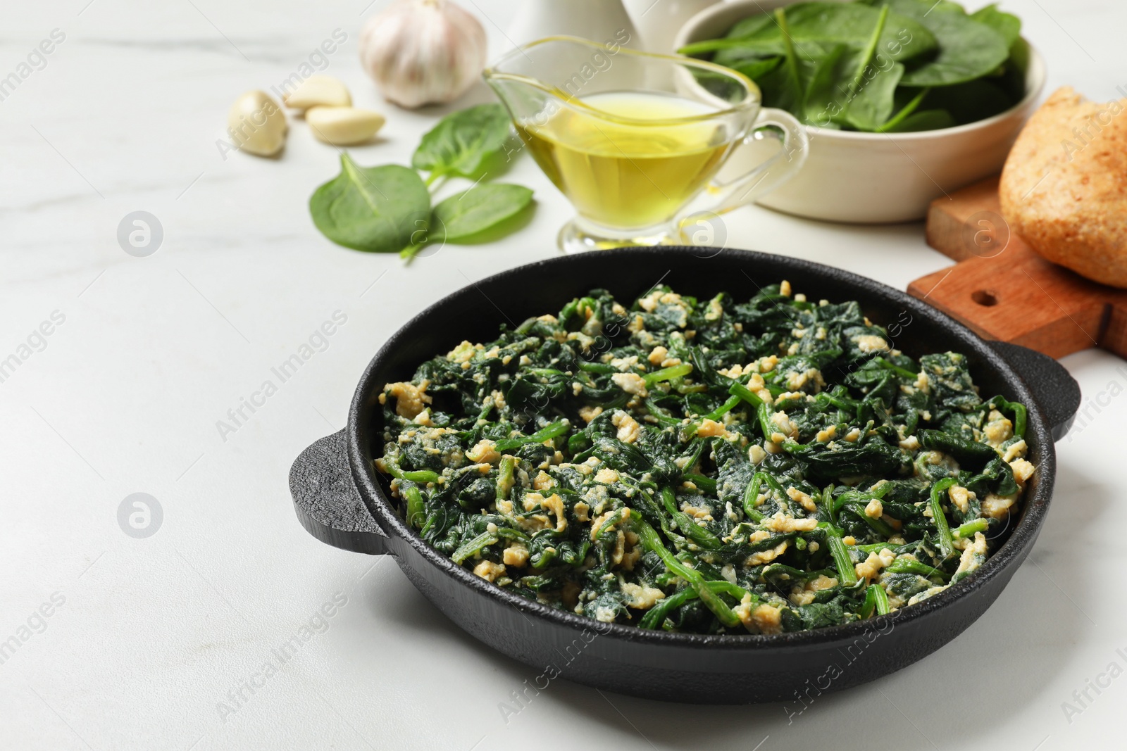 Photo of Tasty spinach dip with eggs in dish served on white table, closeup. Space for text