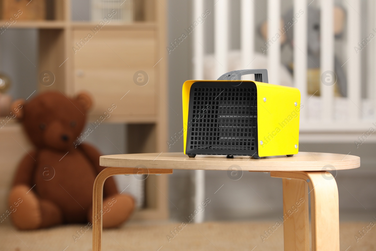 Photo of Modern electric fan heater on coffee table in cozy room. Space for text