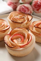 Freshly baked apple roses on plate, closeup. Beautiful dessert