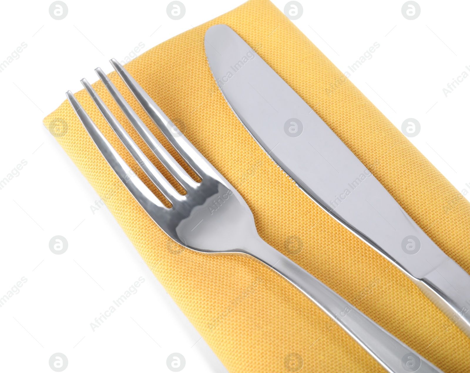 Photo of Yellow napkin with fork and knife on white background, closeup